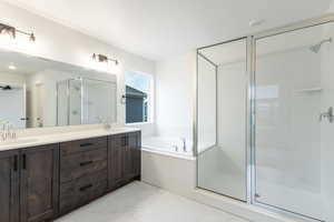 Full bathroom with double vanity, a shower stall, and a garden tub
