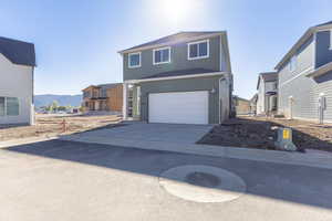 View of front of house featuring an attached garage, concrete driveway, a mountain view, and a residential view