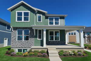 View of front facade with covered porch and board and batten siding