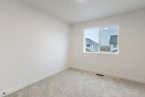 Carpeted spare room featuring baseboards