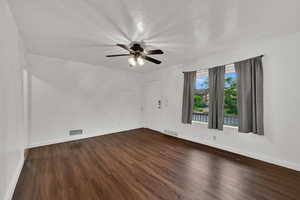Spare room with dark wood-style flooring and ceiling fan