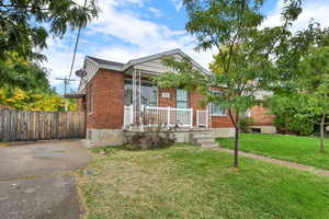 View of front of property with brick siding, covered porch, and driveway