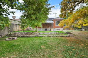 Fenced backyard featuring a fire pit and a patio