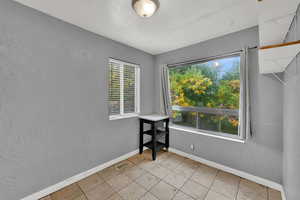 Spare room featuring a textured wall and light tile patterned flooring