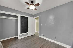 Unfurnished bedroom featuring wood finished floors, a ceiling fan, a textured ceiling, and a closet