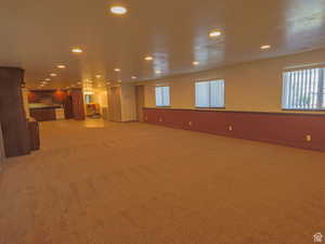 Unfurnished living room featuring recessed lighting, light colored carpet, and healthy amount of natural light