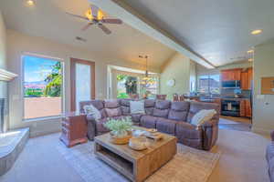 Living area with recessed lighting, ceiling fan, a tiled fireplace, a chandelier, and light colored carpet