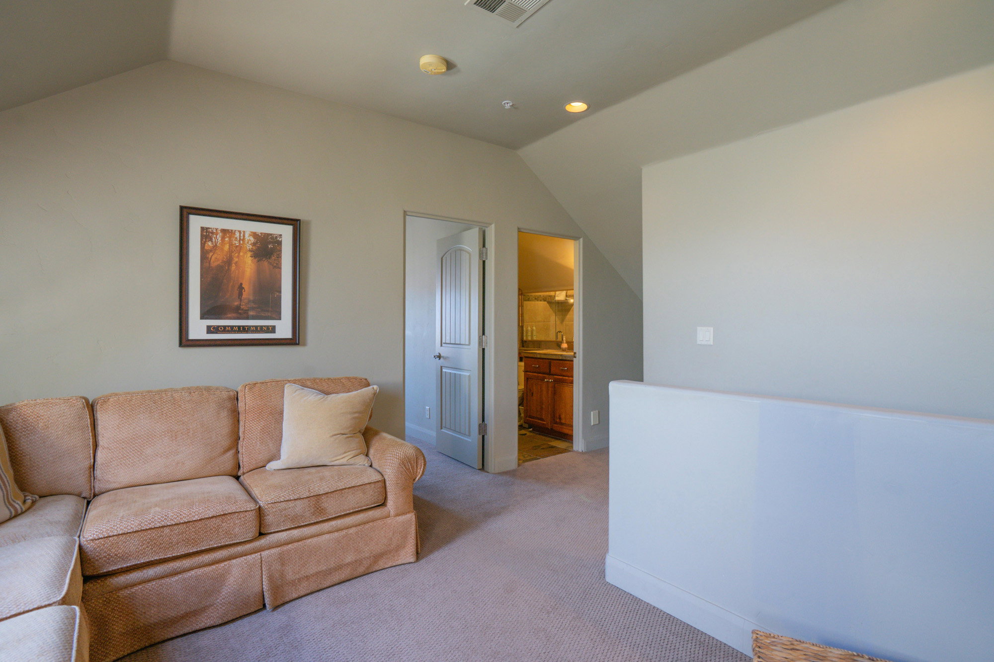 Carpeted living area featuring lofted ceiling and recessed lighting