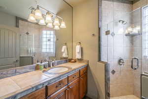 Bathroom with vanity, a stall shower, and plenty of natural light
