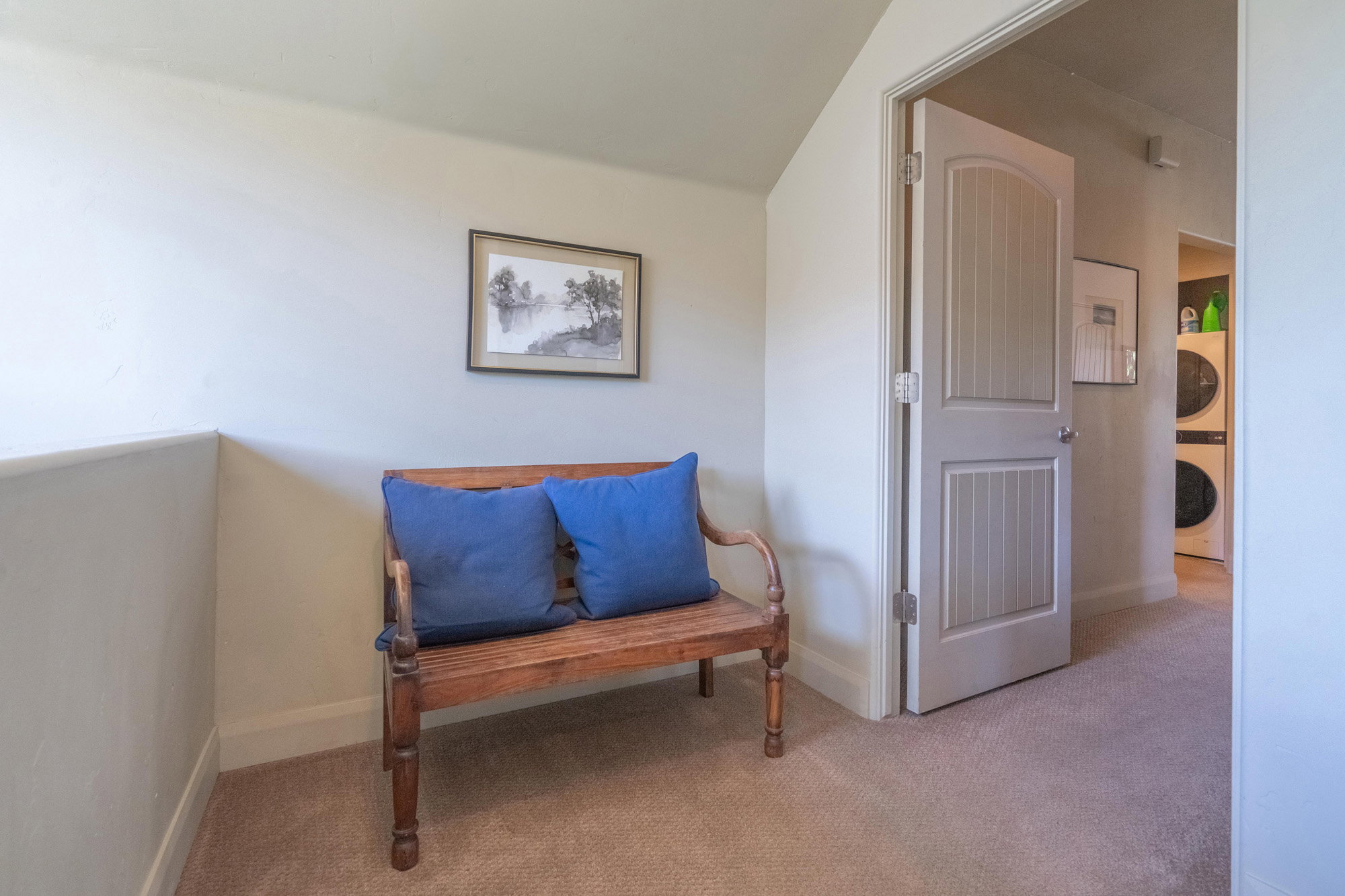 Living area with carpet flooring and stacked washer and clothes dryer