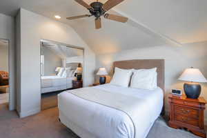 Carpeted bedroom with ceiling fan, lofted ceiling, a closet, and recessed lighting