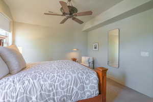 Bedroom featuring carpet floors, ceiling fan, and vaulted ceiling