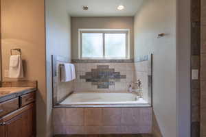 Full bath with vanity and a garden tub