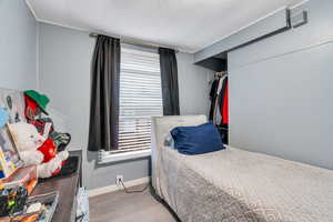 Bedroom featuring a textured ceiling and light wood finished floors