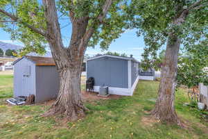View of grassy yard with a storage shed