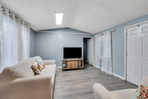 Living room featuring lofted ceiling and wood finished floors