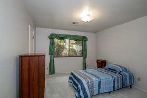 Carpeted bedroom featuring a textured ceiling and baseboards