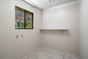 Laundry area with light colored carpet and baseboards