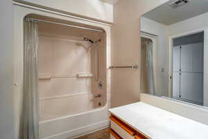 Full bath featuring shower / bath combo with shower curtain, vanity, and light tile patterned floors