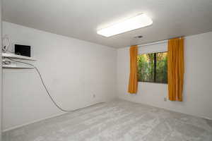 Carpeted empty room featuring a textured ceiling