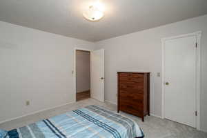 Bedroom with light carpet and a textured ceiling