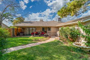 Back of house with a chimney, a patio area, stucco siding, brick siding, and outdoor lounge area