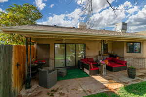 Rear view of property with brick siding, stucco siding, roof with shingles, and a ceiling fan