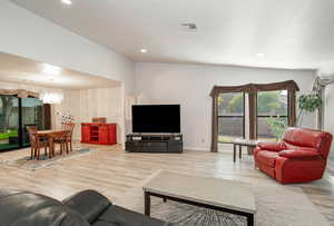 Living room featuring light wood finished floors, recessed lighting, and a chandelier