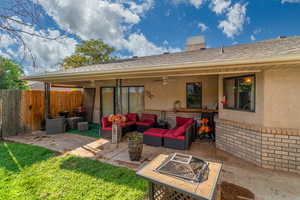 Rear view of property with stucco siding, brick siding, and a ceiling fan