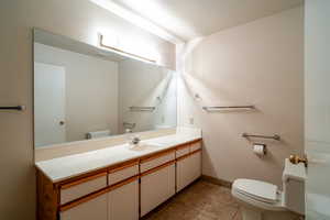 Half bath with vanity and dark tile patterned flooring