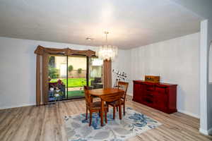 Dining space featuring light wood-style flooring and a chandelier