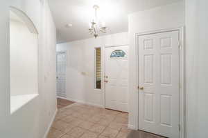 Foyer entrance featuring light tile patterned floors and a chandelier