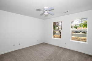 Unfurnished room featuring carpet flooring and a ceiling fan