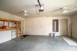 Garage featuring a ceiling fan, water heater, and a garage door opener