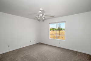 Empty room featuring carpet floors and ceiling fan