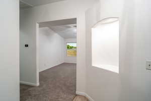 Hallway featuring light carpet and baseboards
