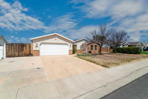 Single story home with concrete driveway, brick siding, and a garage