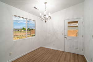Unfurnished dining area featuring a mountain view, wood finished floors, and a chandelier
