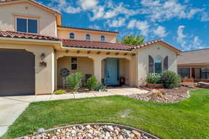 Mediterranean / spanish house with stucco siding, a garage, a front lawn, and a tile roof