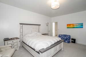 Bedroom with light carpet and baseboards