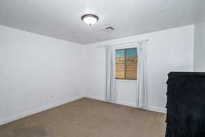 Spare room with light carpet and baseboards
