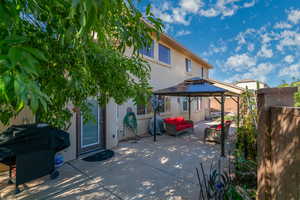 Back of house with a patio area, a gazebo, stucco siding, outdoor lounge area, and a tiled roof