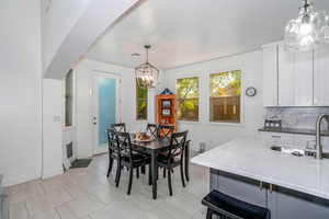 Dining space with light tile patterned floors and a chandelier