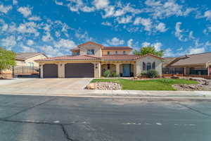 Mediterranean / spanish house with stucco siding, driveway, a tiled roof, and a garage