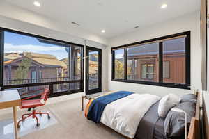 Bedroom with two walls of windows, mountain views and access to a private deck.
