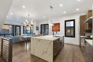 Kitchen featuring decorative light fixtures, light wood-style flooring, light stone countertops, recessed lighting, and modern cabinets