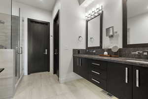 Full bathroom featuring double vanity, a shower stall, light tile patterned flooring, and recessed lighting
