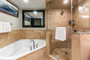 Full bath with a shower stall and a jetted tub