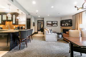Dining area featuring light colored carpet, recessed lighting, and a glass covered fireplace