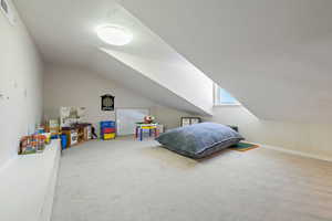 Bedroom featuring carpet floors and lofted ceiling